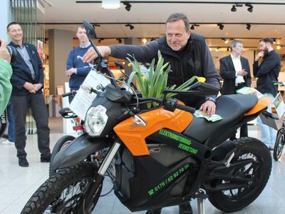 Bild vergrößern: Der Energiebeauftragte Uwe Hergert an einem neuen E-Motorradmodell in der Ausstellung am Plauen Park.